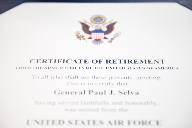 Rahmenurkunde zur Verabschiedung von der United States Air Force mit blauem Rand, die ein zentrales Sternschild-Logo zeigt, das von einem Lorbeerkranz umgeben ist und eine "Verabschiedung"-Bannertrage, alles in Schwarz gedruckt.