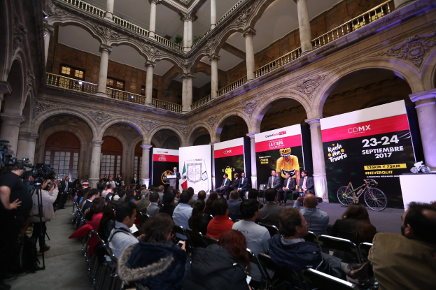 Eine Gruppe von Menschen sitzt an einem Tisch mit einem Podium und Mikrofon vor einer Menge, Kameras und Schildern während einer Pressekonferenz zum CDMX 2017-Event.