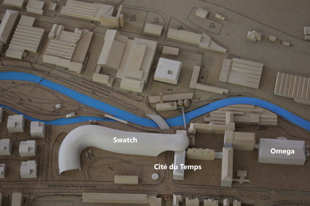 Ein Modell einer Stadt mit einem Fluss, Gebäuden, Straßen und Text.