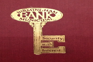 Ein rotes Buch mit einem goldenen Schlüssel darauf, beschriftet mit "Birmingham Bank Municipal Security mit Zinsen."
