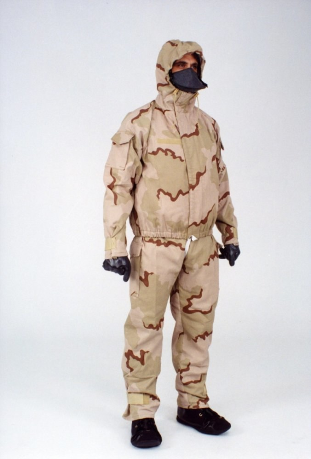 Mann in einem weißen Schutzoverall mit Kapuze und Maske, der für den Schutz vor gefährlichen Materialien entworfen wurde, steht vor einem weißen Hintergrund.