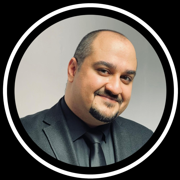 Ein Mann in Anzug und Krawatte mit einem freundlichen Gesichtsausdruck vor einem schwarzen Hintergrund, betitelt als Anwalt in New York City.